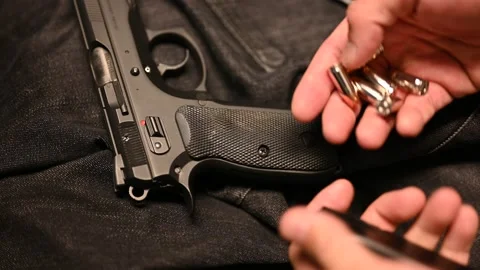 Loading self defense rounds in a magazine of a concealed carry gun Stock Footage 145915206