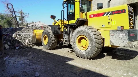 Loading shovel clearing rubble from streets of Raqqah, Syria Stock Footage 94565326