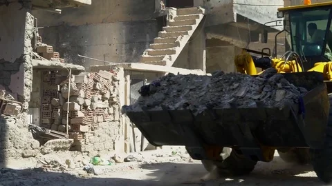 Loading shovel clears rubble from streets of Raqqah, Syria Stock Footage 94565348
