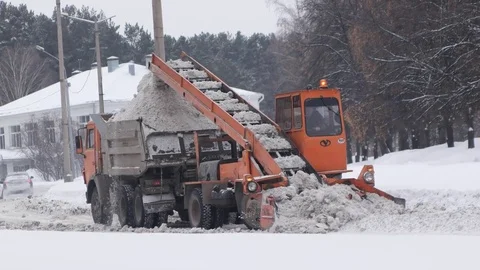 Loading snow to overflowing truck. Сlearing streets of snow using machines Stock-Footage 70788202