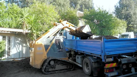 Loading some soil into the truck with the help of the trachtor loader Stock Footage 147217172