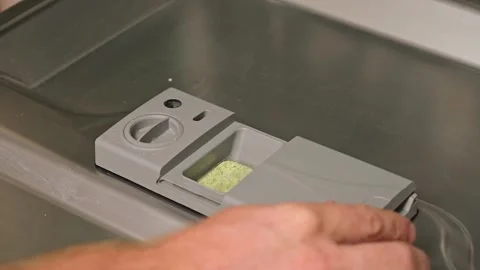 Loading the tablet into the dishwasher. A man puts tablet in the dishwasher to Stock Footage 244637743
