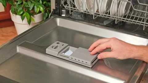 Loading the tablet into the dishwasher. A man puts tablet in the dishwasher to Stock Footage 244637790