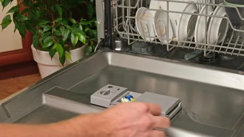 Loading the tablet into the dishwasher. A man puts tablet in the dishwasher to Stock Footage 244803841