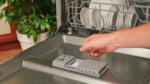 Loading the tablet into the dishwasher. A man puts tablet in the dishwasher to Stock Footage 245209092
