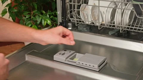 Loading the tablet into the dishwasher. A man puts tablet in the dishwasher to Stock Footage 246070640