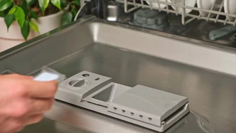 Loading the tablet into the dishwasher. A man puts tablet in the dishwasher to Stock Footage 246641314