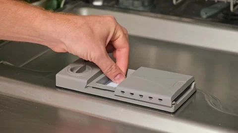 Loading the tablet into the dishwasher. A man puts tablet in the dishwasher to Stock Footage 246915439