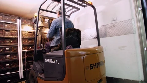 Loading of a truck. a worker on a small auto-loader, Electric forklift truck Stock Footage 95958952