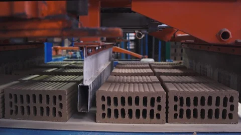 Loading vehicle moves blocks of bricks onto a manufacturing line, close up shot Stock Footage 128161120