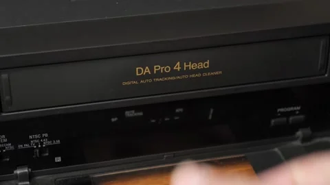 Loading a VHS tape into a video player. Video imaging technologies. Stock Footage 233431914