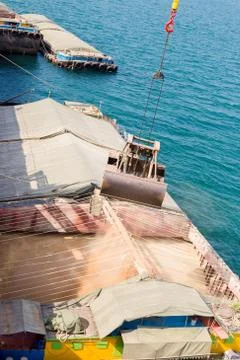 Loading wheat on cargo ship with crane and bucket. Shipment from a merchant s 写真素材