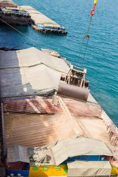 Loading wheat on cargo ship with crane and bucket. Shipment from a merchant s Stock Photos