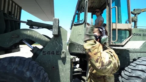 Loadmaster guiding forklift truck operator loading steel container onto C-130 Stock Footage 113610587