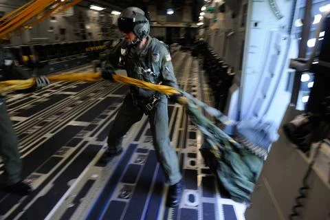 A loadmaster pulls parachute rigging into a C-17 Globemaster III June 16 i... Stock Photos