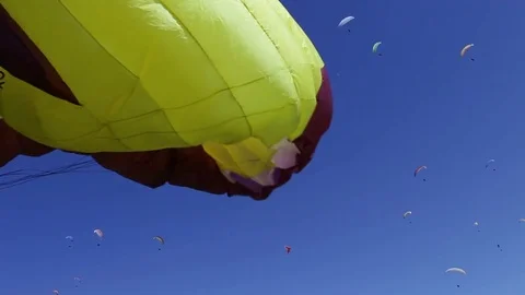Loads of paragliders soar in the blue sky on a clear day Video stock 76811087