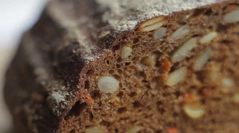 Loaf and slices of black bread with grains. Close up slow panorama Stock Footage 50363011