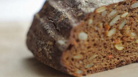Loaf and slices of black bread with grains. Close up slow panorama Stock Footage 50363026