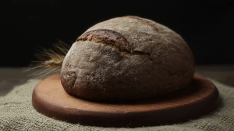 A loaf of black bread with rye ears on a rotating tray Stock Footage 192922051