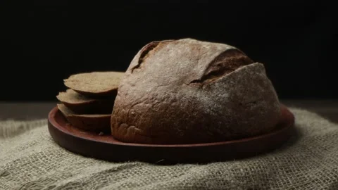 A loaf of black bread with slices on a rotating tray Stock Footage 192921895