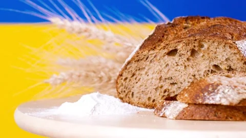 A loaf of bread and cut slices rye ears on wooden tableon the background of the Video stock 202047529