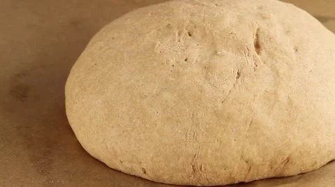 A loaf of bread being brushed with water, scored and sprinkled with sunflower Stock Footage 24672978