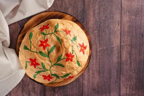 Loaf of bread hand painted with edible paints on a wooden board top view Stock Photos