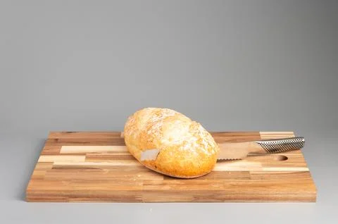 Loaf of Bread with Knife on Cutting Board Foto stock