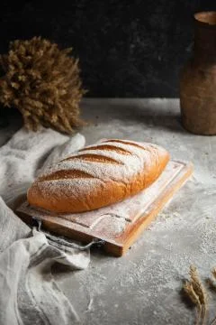 A loaf of bread lies on a wooden table Stock Photos