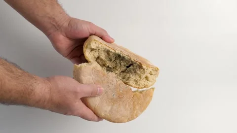 A loaf of bread with mold is broken in half.  Disposal of bread. Stock Footage 299835742
