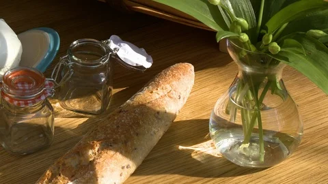 A loaf of bread next to a vase with plants Stock-Footage 115886232