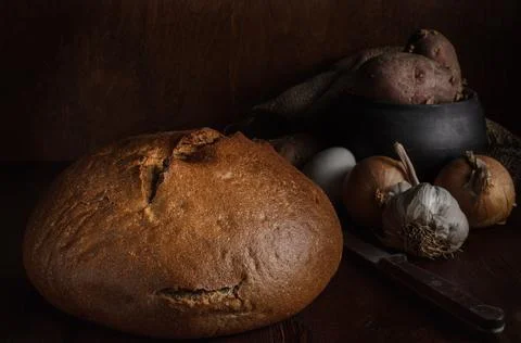 Loaf of bread in rustic style on dark wooden background Stock Photos