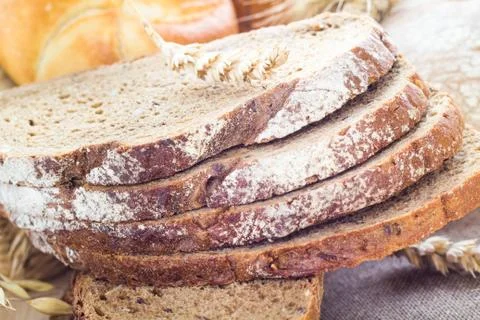 Loaf of bread sliced with crispy rolls Stock Photos