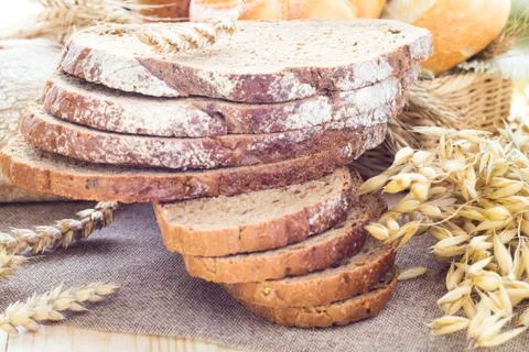 Loaf of bread sliced with crispy rolls Stock Photos