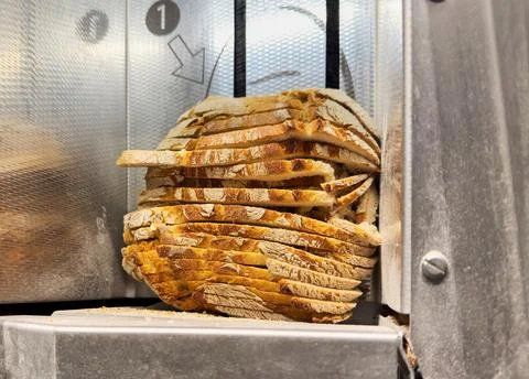 Loaf of Bread in Slicing Machine Stock Photos