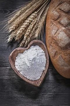 Loaf of bread Wheat Rye Ears Wooden bowl with flour on wooden board 스톡 사진