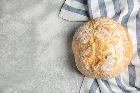 Loaf of fresh bread on grey marble background, top view. Space for text Stock Photos