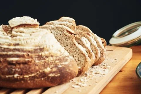 A loaf of fresh sliced bread on a bread board Photos