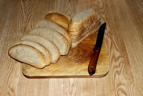 A loaf of gray bread cut into pieces on the table. Foto stock