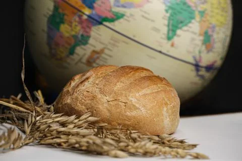 A loaf of round wheat bread wrapped with barbed wire. The concept of food crisis Stock Photos