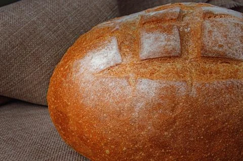 Loaf of round white bread on the background of linen cloth. Foto stock