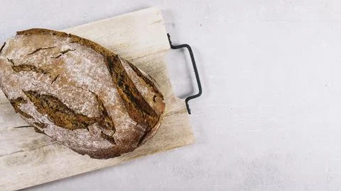 Loaf rustic baked bread chopping board white background Stock Photos