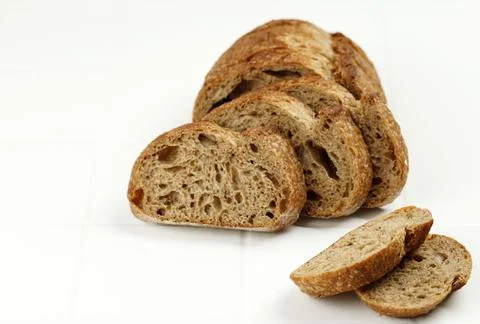 Loaf of Rye Bread Cut into Slices on White Background Stock Photos