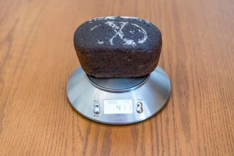 A loaf of rye bread on the scales Stock Photos