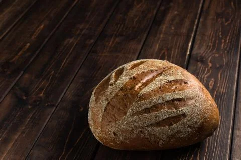 Loaf of rye fresh bread lying on an old wooden table. rural food background w Stock-Fotos