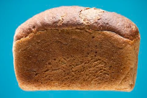Loaf of rye-wheat bread isolated on a blue background Stock Photos
