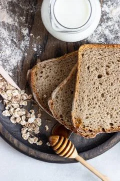 Loaf of sliced rye bread on old wooden tray. Stock Photos