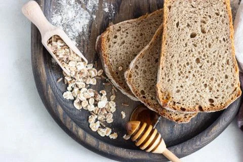 Loaf of sliced rye bread on old wooden tray. Stock Photos