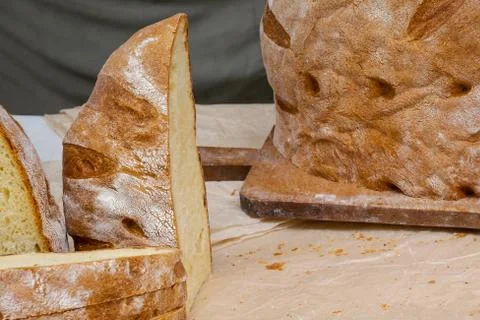 Loaf of traditional rustic bread on cutting board and cut slices of bread Stock Photos