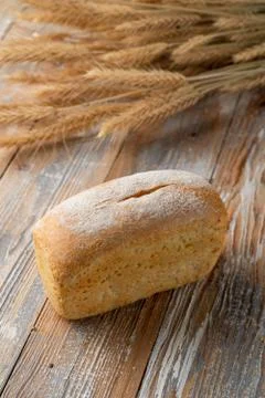 A loaf of white wheat bread on old wooden background Stock Photos